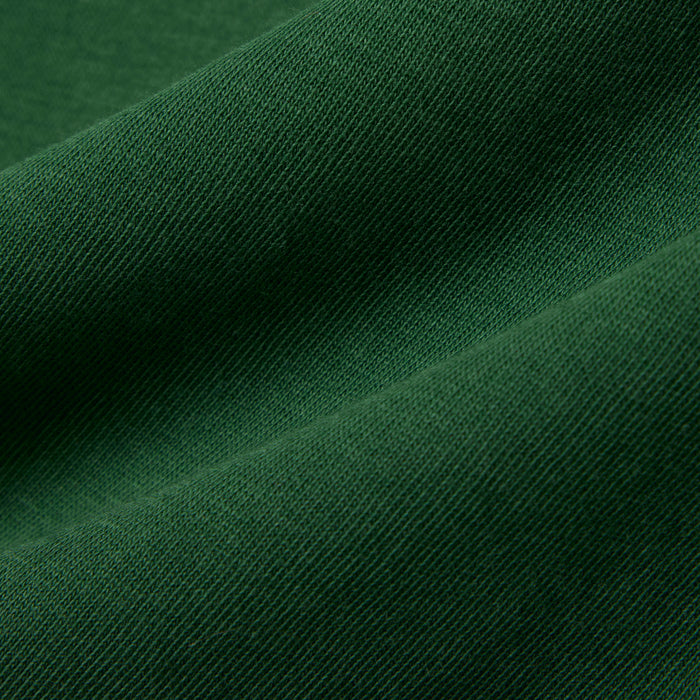 Green cotton fabric close-up showing texture and weave, ideal for baby and kids clothing.