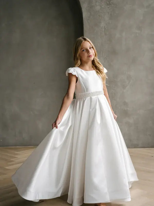 Teter Warm Charlotte Satin Communion Dress worn by a girl standing in a modern studio setting.