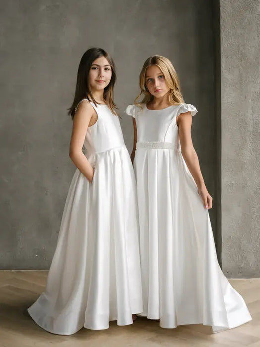Charlotte satin communion dress shown on two girls standing against a neutral wall.