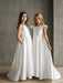 Charlotte satin communion dress shown on two girls standing against a neutral wall.