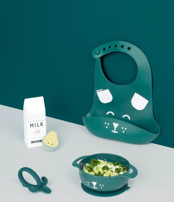 Green silicone baby bib and bowl set with animal face, teether, food, and milk carton