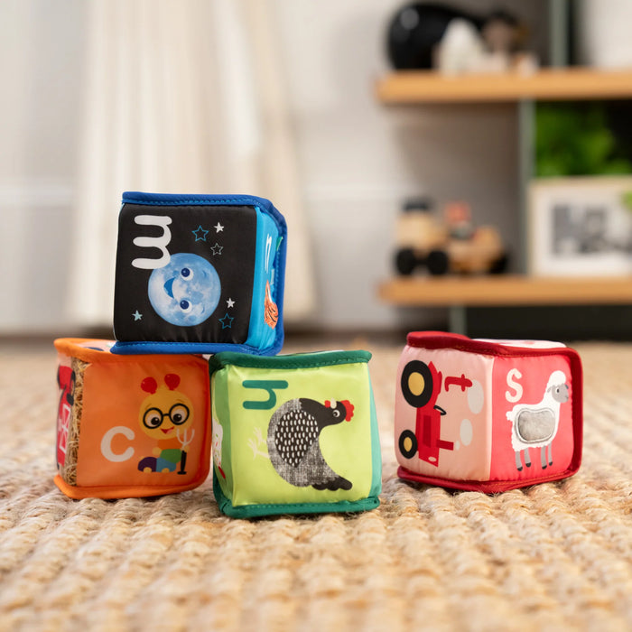 b.box alpha skating soft sensory toy blocks stacked on a carpeted floor in a playroom