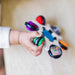 b.box baby sensory toy clutch held by a child's hand on a light surface