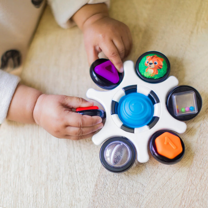 b.box baby sensory toy clutch being explored by a baby on a wooden surface