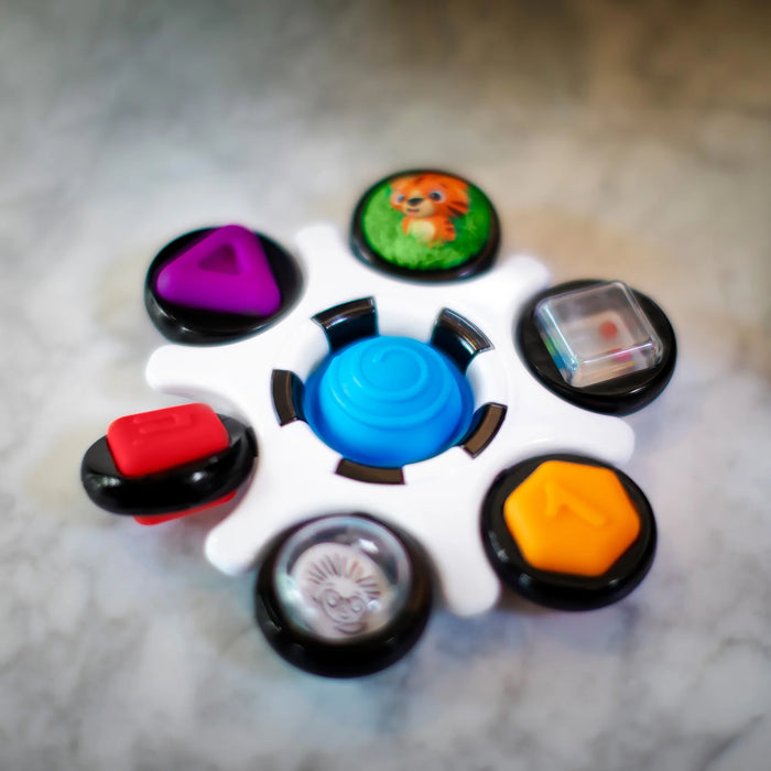 b.box baby sensory toy clutch with colorful buttons and shapes on a marble surface.