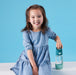 b.box kids tritan drink bottle shown upright on a white surface beside a smiling child in a blue dress.