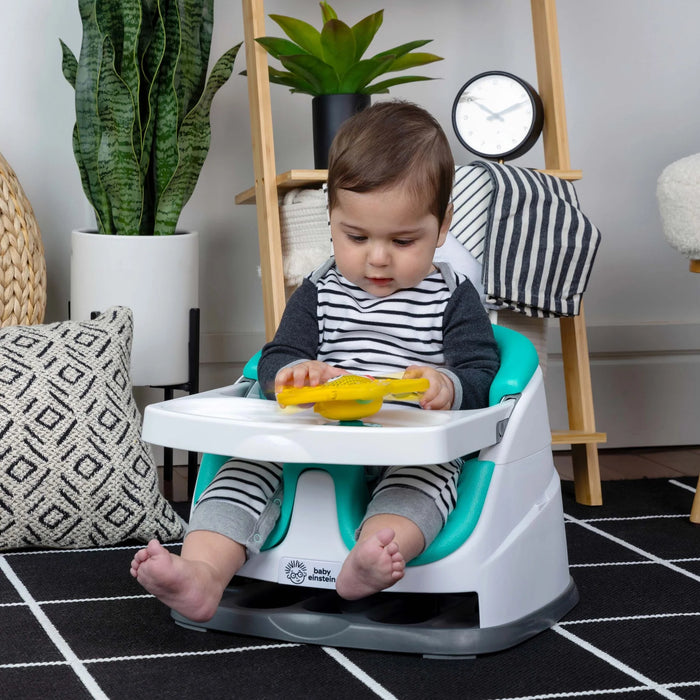 b.box Pop & Glow Starfish Sensory Toy held by a baby sitting in a high chair indoors