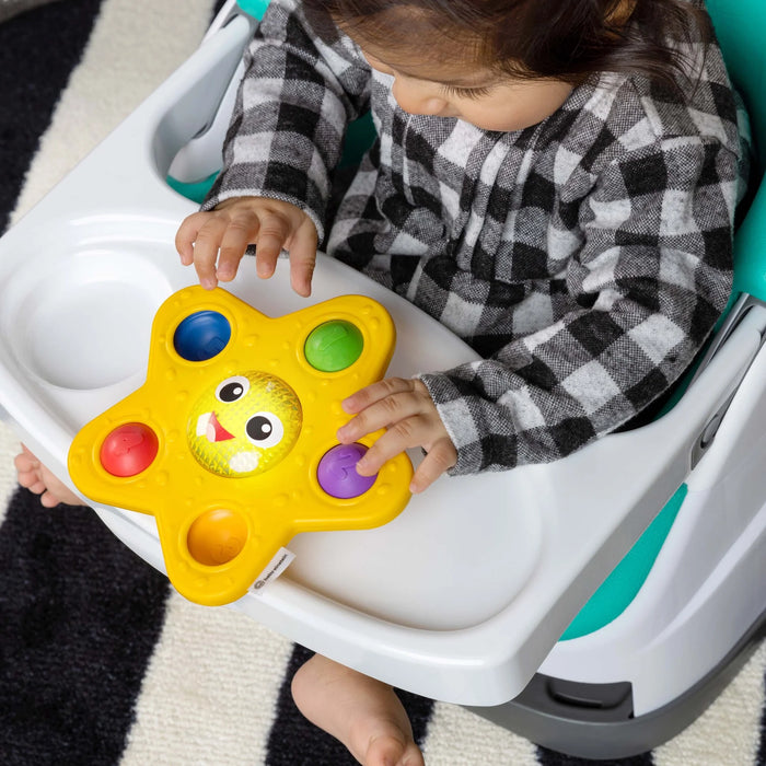 b.box pop and glow starfish sensory toy held by a toddler seated in a high chair