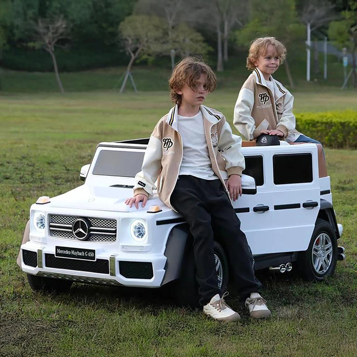 Mercedes-Maybach G 650 kids ride-on car with two children sitting on it outdoors.