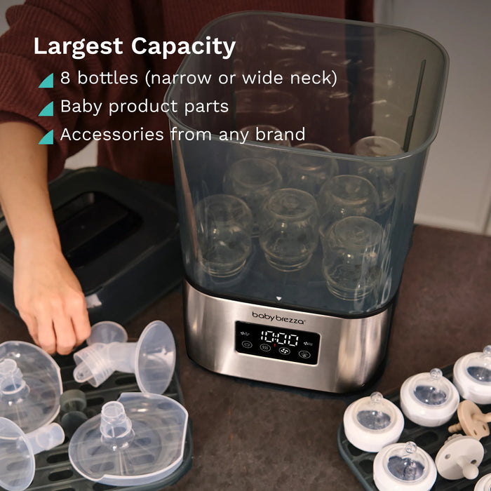 Baby Brezza Super Fast Sterilizer and Dryer with baby bottles and accessories on a kitchen counter.