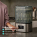 Baby Brezza Super Fast Sterilizer and Dryer on a kitchen counter with a hand pressing a button.