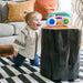 Baby Einstein Toddler Jams musical toy on a wooden table with a smiling child on a play mat.