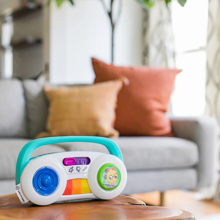 Baby Einstein Toddler Jams musical toy sitting on a wooden table in a cozy living room.