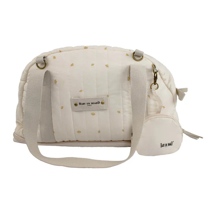 Baby on Board cotton diaper bag in cream with subtle gold prints, shown on a plain background.
