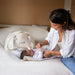 Baby on Board doudoune cotton diaper bag beside a baby being changed on a bed.