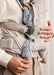 BabyBjorn Harmony baby carrier in beige with baby worn on adult's chest, close-up view.