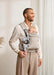 BabyBjörn Harmony baby carrier beige with baby facing inward, worn by an adult in a home setting.