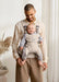 BabyBjorn Harmony baby carrier in beige worn by a smiling adult holding a happy baby indoors.