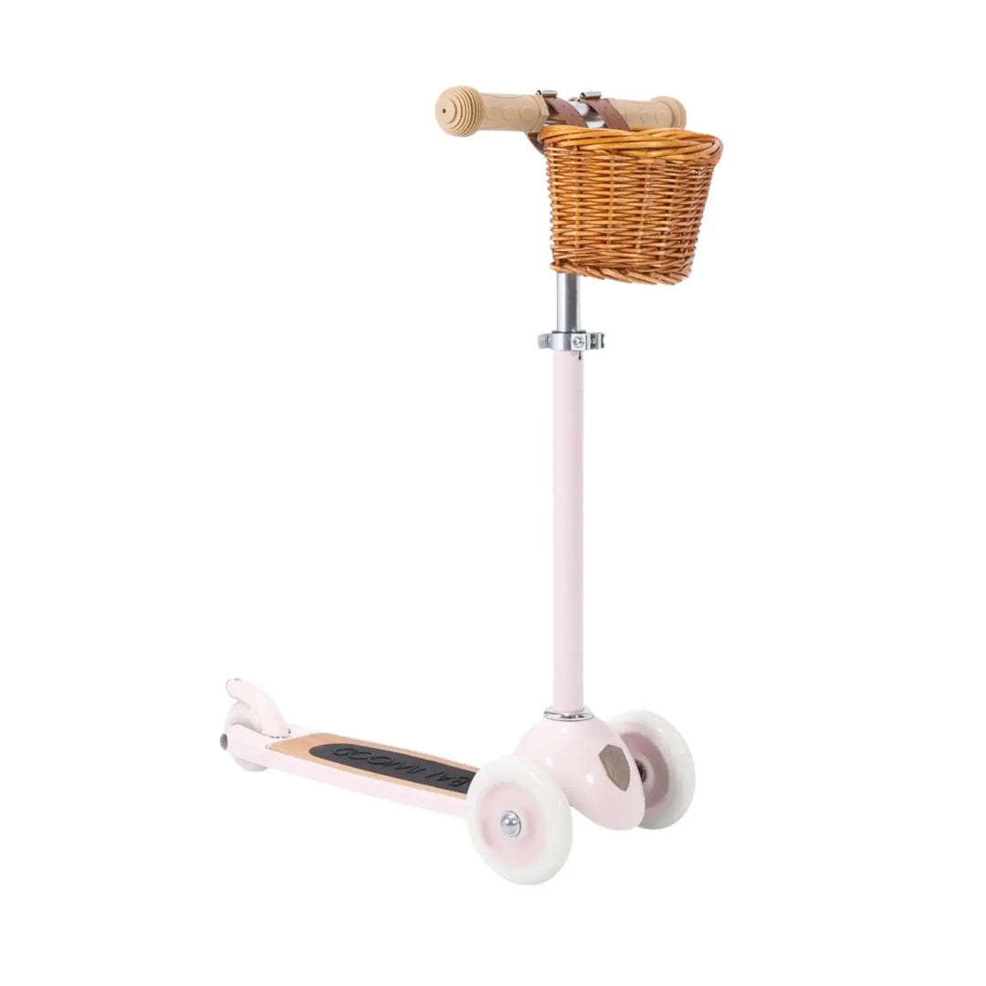 Banwood 3 wheel scooter in pastel pink with a wicker basket, shown on a white background.
