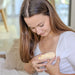 BBLÜS Mumpulse 3-in-1 Lactation Massager being used by a woman on her chest at home.