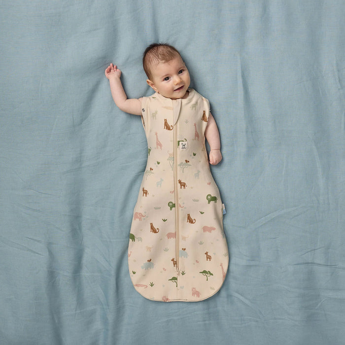 Bbox Cocoon Swaddle Sac 0.2 TOG in oatmeal daisies design on a baby lying on a blue blanket.