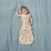 Bbox Cocoon Swaddle Sac 0.2 TOG in oatmeal daisies design on a baby lying on a blue blanket.