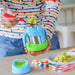 bbox insulated food jar 335ml ocean breeze held by an adult at a table, food being scooped out with a spoon.