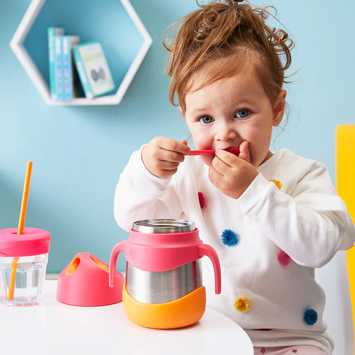 bbox insulated food jar strawberry shake used by a toddler at a table in a colorful room.