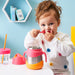 bbox insulated food jar strawberry shake used by a toddler at a table in a colorful room.