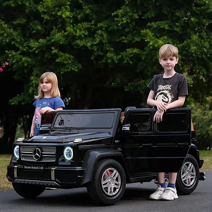 Mercedes Maybach G 650 kids ride-on car with two children outdoors on a sunny day.