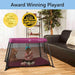 Dream On Me Travel Light Pink playard with a baby inside, set up in a living room next to a sofa.