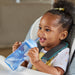 NUK blue straw cup held by smiling baby sitting in a high chair