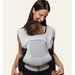 Flybaby 3D baby carrier in light grey shown worn by an adult carrying a baby on their chest.