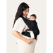 Flybaby 3D Baby Carrier in black shown on a woman carrying an infant facing inward.