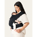 Flybaby 3D baby carrier in black shown worn by an adult holding a sleeping baby close to their chest.