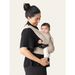 Flybaby 3D baby carrier in beige shown worn by an adult carrying a baby on their chest