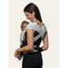 Flybaby 3D Baby Carrier in grey worn by a woman carrying a smiling baby on her front.