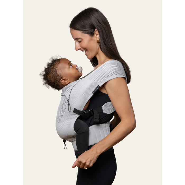 Flybaby 3D Baby Carrier in light grey, shown with baby facing parent in soft fabric support.