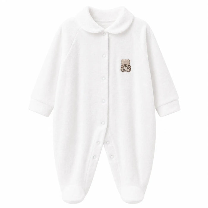 White baby pyjama with teddy bear patch on chest, displayed flat on a plain background.
