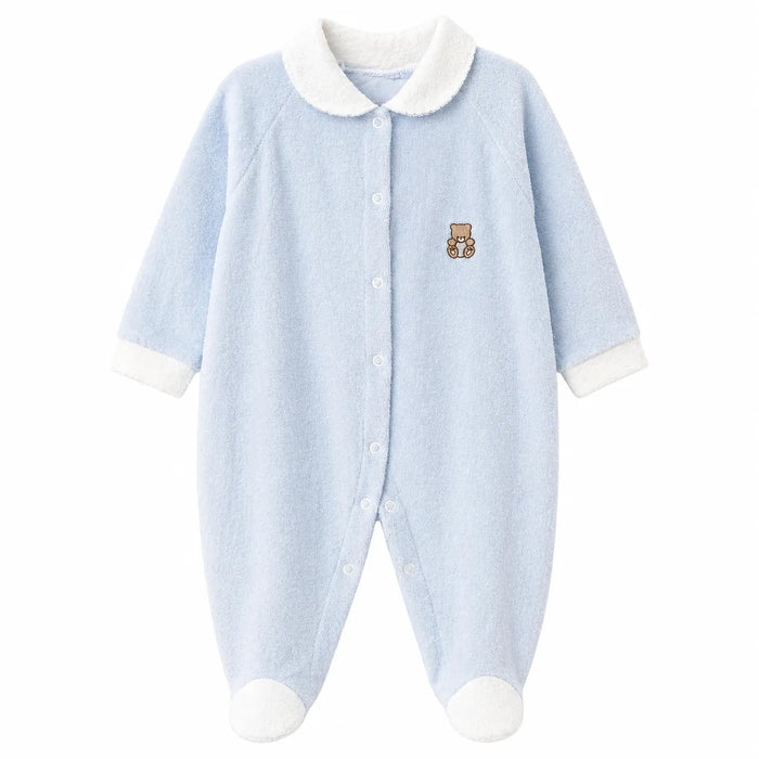 Light blue baby pajama with white cuffs and collar, teddy bear patch on chest, shown on white background.