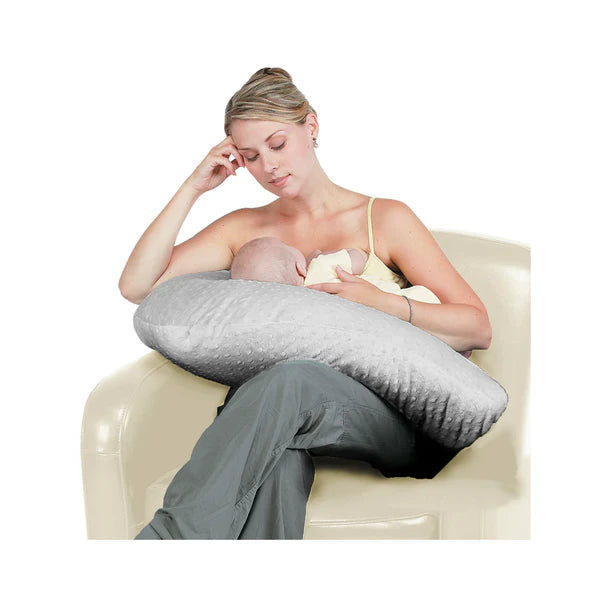 Jolly Jumper Boomerang Nursing Pillow supporting a mother breastfeeding her baby on a chair.