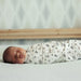 Koala Baby 4-Pack Flannel Receiving Blanket with woodland animal print shown wrapped around sleeping infant.