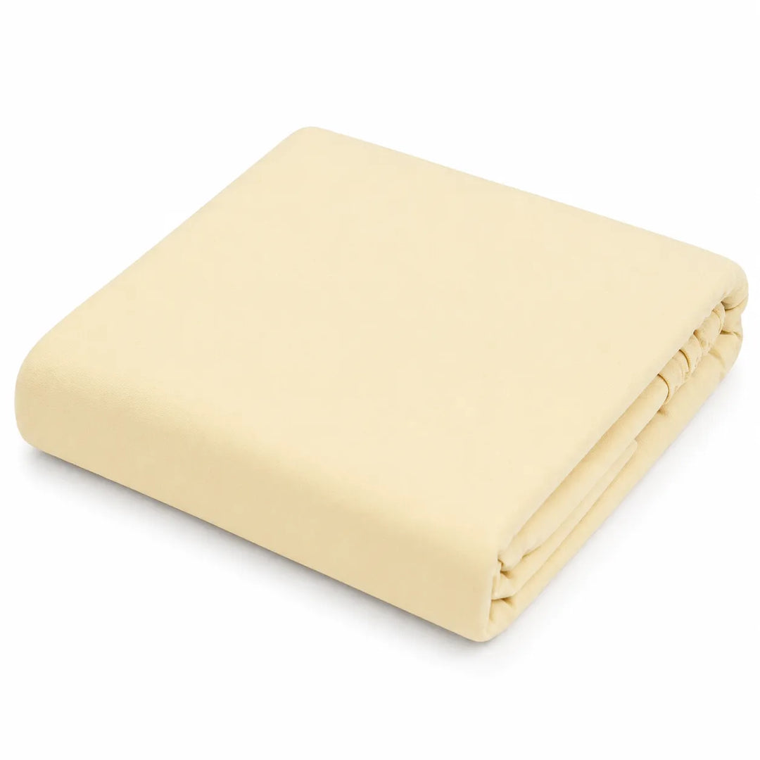 Kushies jersey fitted crib sheet in solid light beige, neatly folded on a white background.
