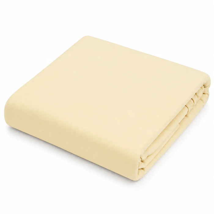 Kushies jersey fitted crib sheet in solid light beige, neatly folded on a white background.