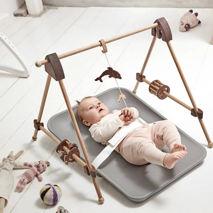 Leander Matty baby changing waterproof mat with infant lying on it in a modern nursery setting.