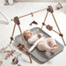 Leander Matty baby changing waterproof mat with infant lying on it in a modern nursery setting.