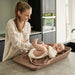 Leander Matty baby changing waterproof mat with a smiling infant on a kitchen counter.