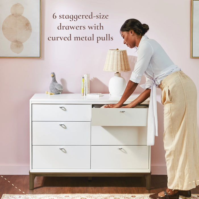 Little Seeds Laurel 6 Drawer Dresser shown in a pink nursery with a woman opening a drawer.