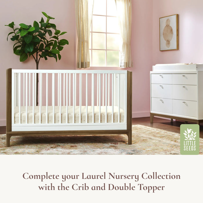 Little Seeds Laurel 6 Drawer Dresser in a pink nursery next to a crib and large window.