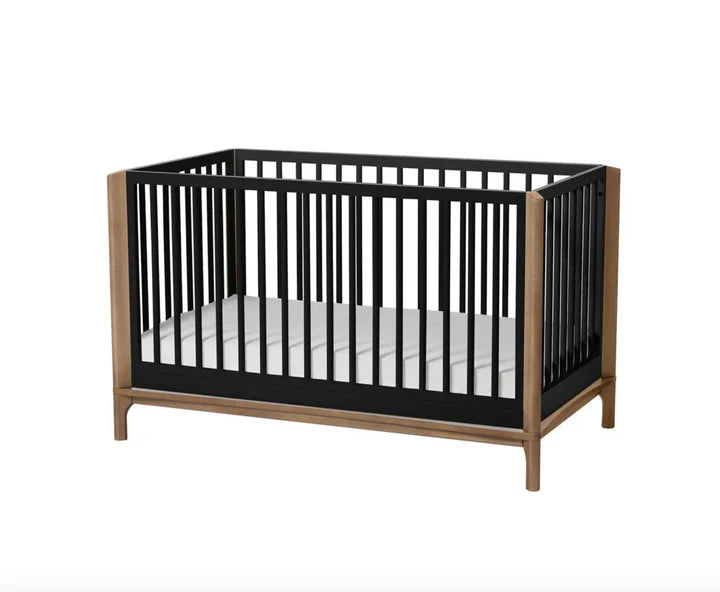 Little Seeds Laurel Island convertible crib with black slats and natural wood frame on white background.